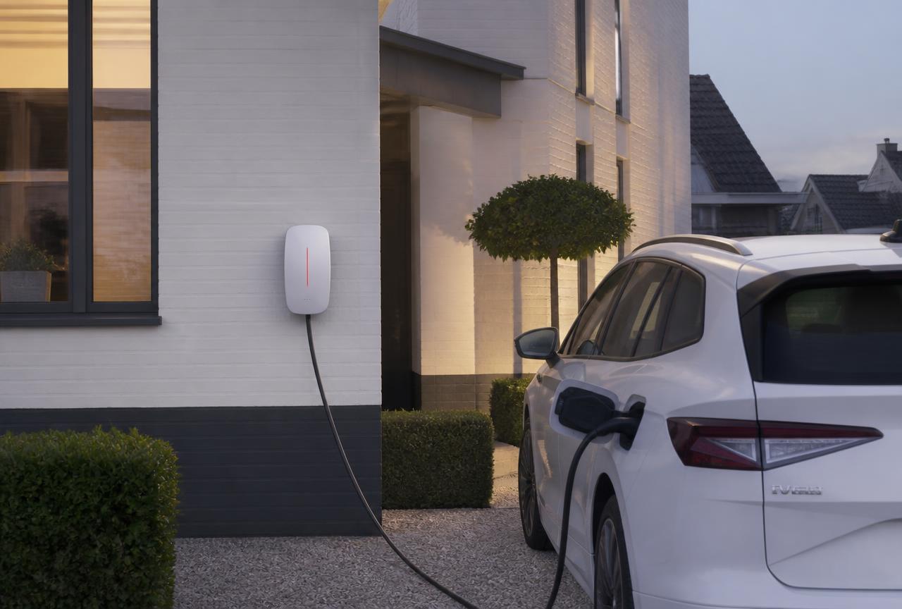 Thuislader aan een woning met een elektrische wagen op de oprit